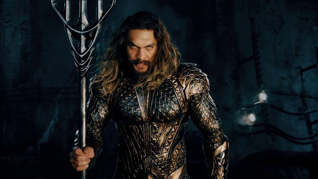 Jason Momoa como Aquaman, armadura dorada y tridente alzado, mirada hacia ti, en Justice League