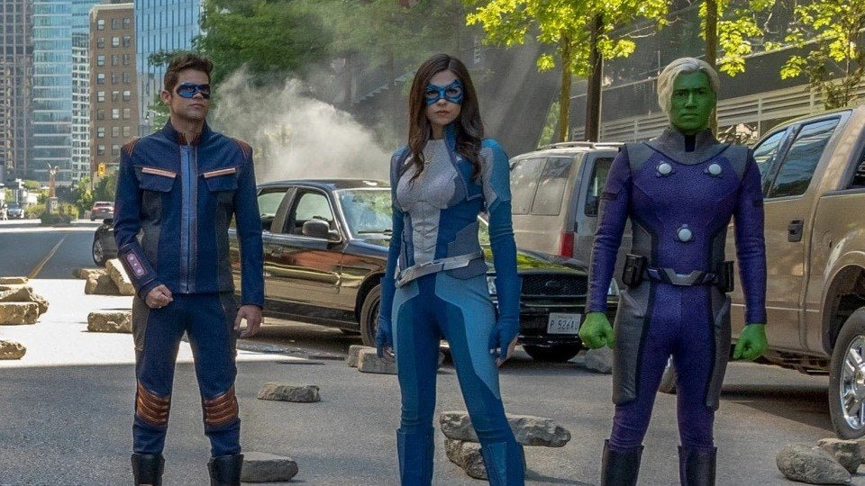 Nicole Maines como Dreamer (Nia Nal), con máscara y traje azules, entre Winn y Brainy en la serie Supergirl