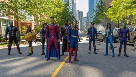 Melissa Benoist como Supergirl en medio de su equipo, en una calle de National City (serie 2015-2021)