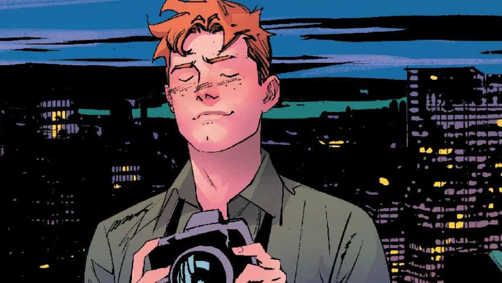 Jimmy Olsen, cámara en mano, ante las luces de Metrópolis de noche