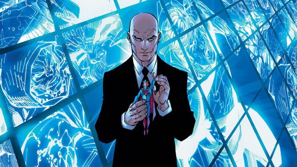 Lex Luthor con traje oscuro ante una pared de cristal azul