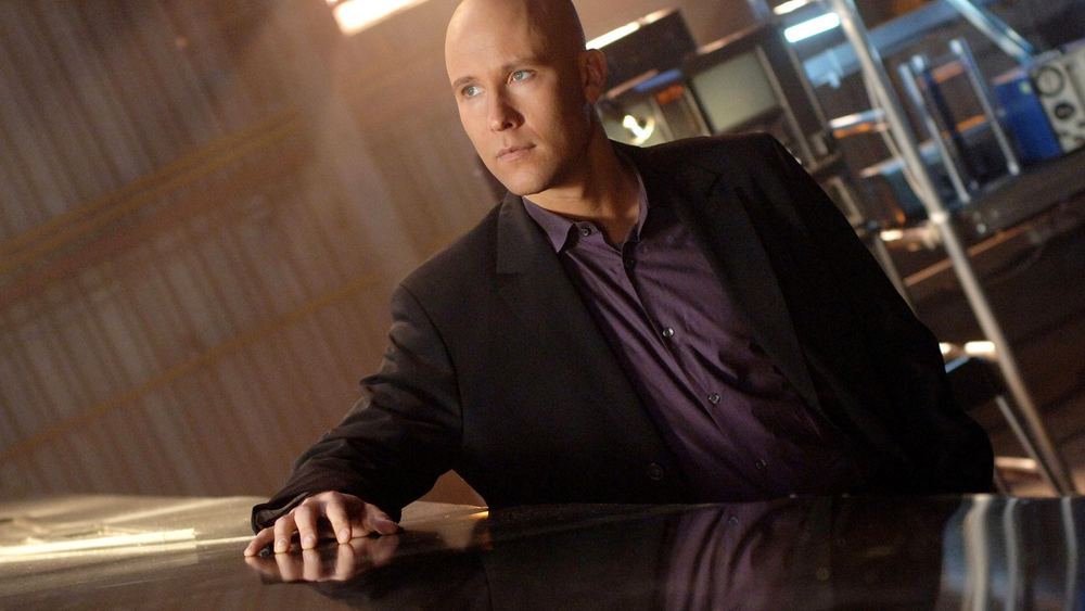 Michael Rosenbaum como Lex Luthor, cráneo rapado, traje oscuro, en Smallville