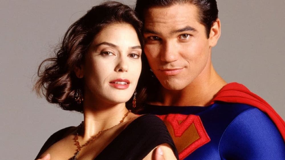 Teri Hatcher como Lois Lane, vestido negro, Dean Cain como Superman detrás de ella